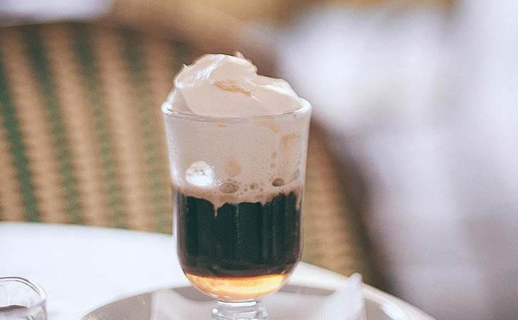 Irish Coffee in a clear glass on a white table